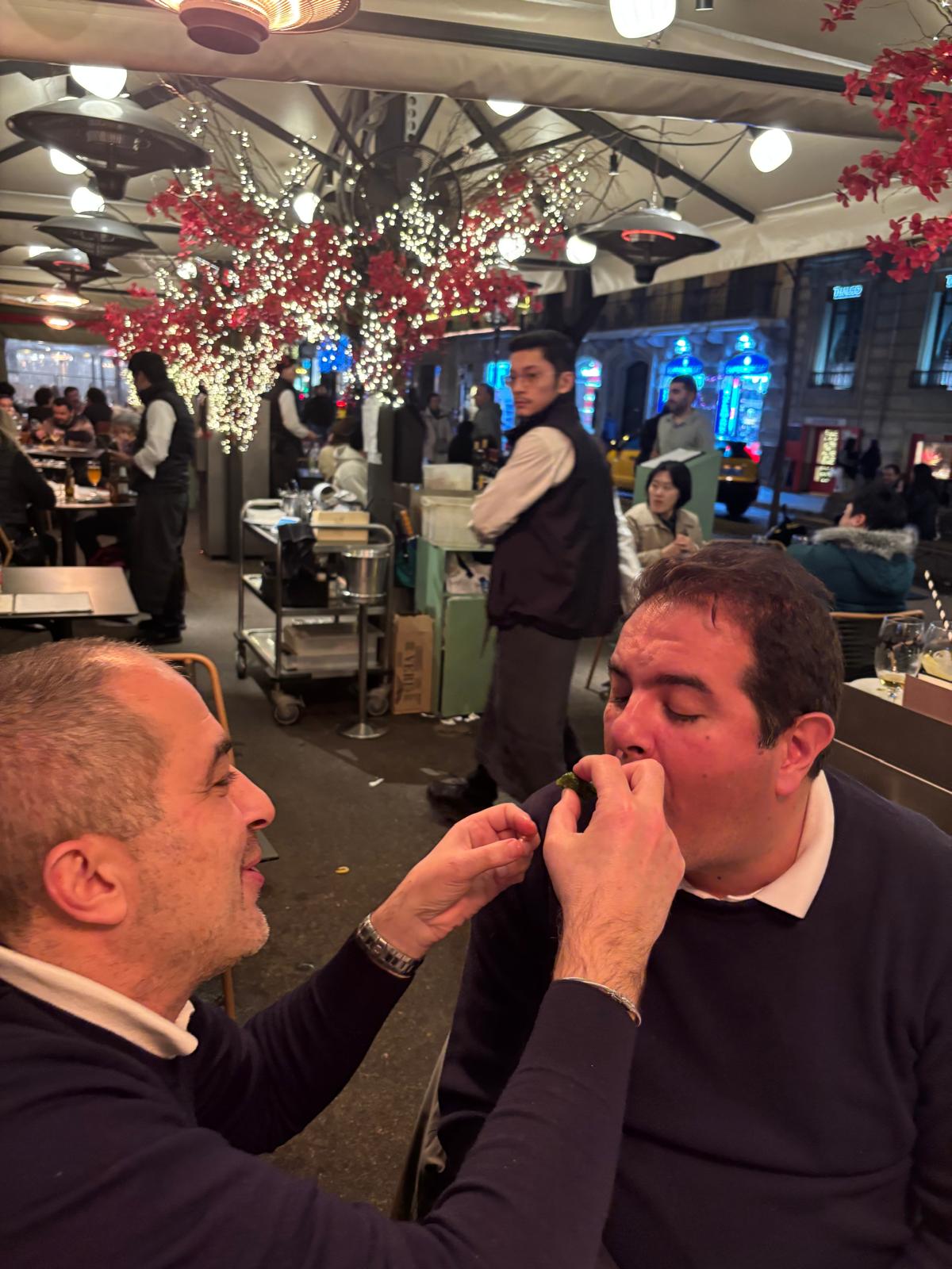 Aydin goûte un piment avec gravité pendant que Mert supervise